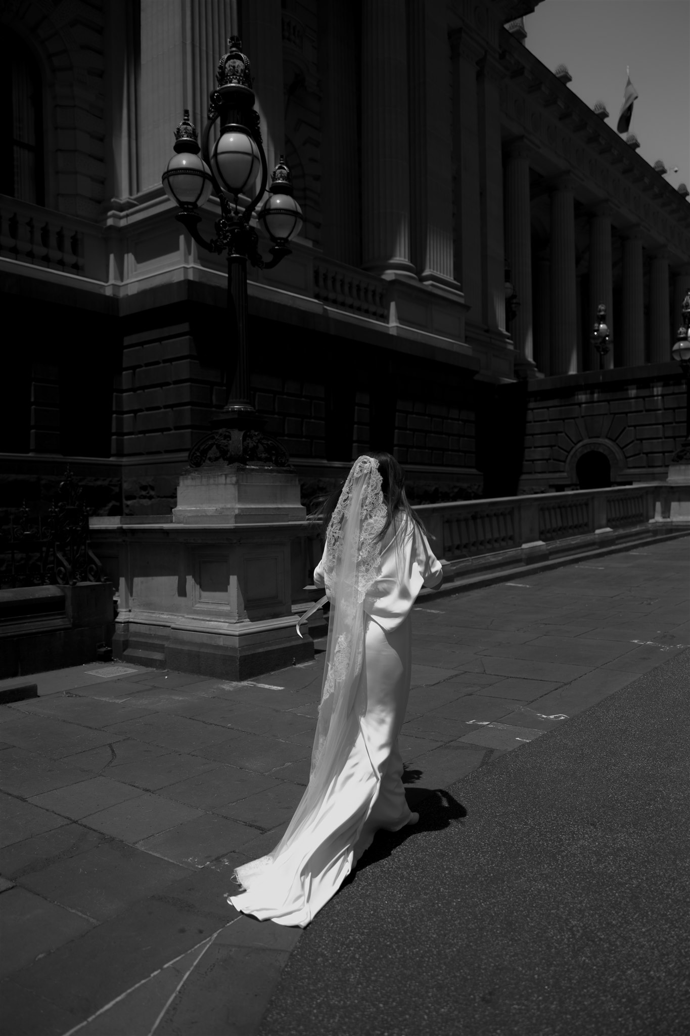 Stylish bride Lindsay in a Lola Varma dress and cowgirl boots, celebrating her Melbourne City elopement at the Melbourne Registry Office