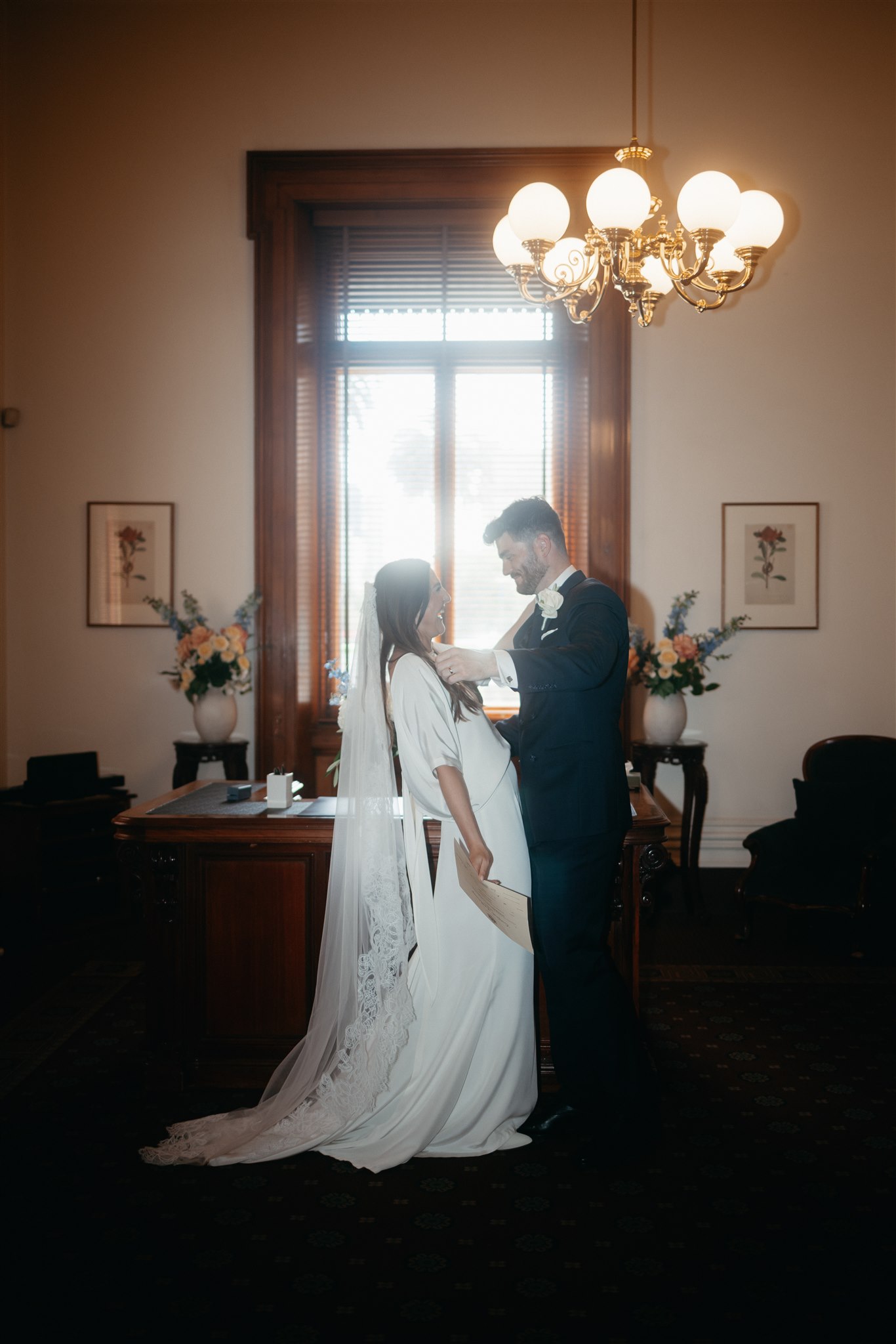 Stylish bride Lindsay in a Lola Varma dress and cowgirl boots, celebrating her Melbourne City elopement at the Melbourne Registry Office