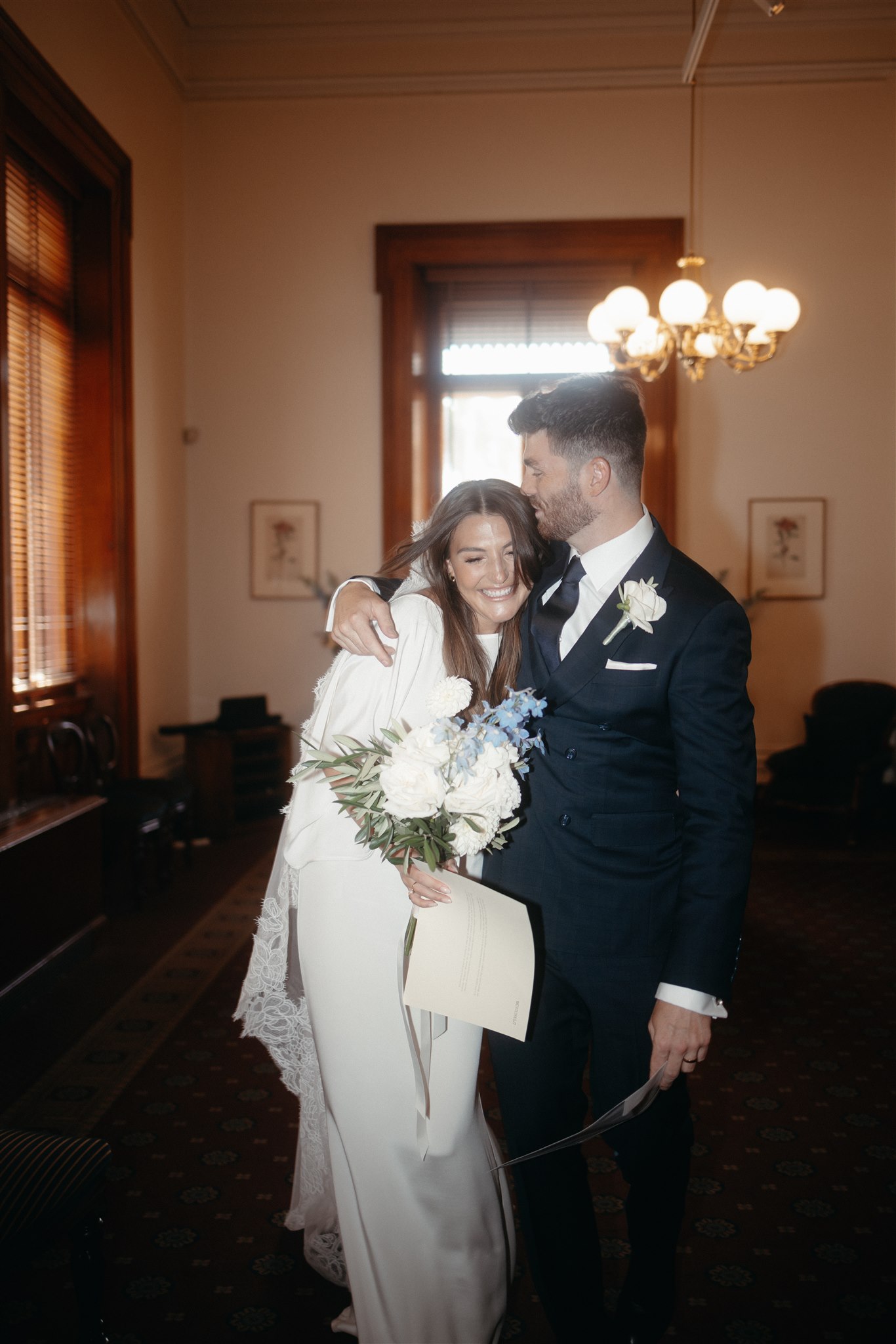 Stylish bride Lindsay in a Lola Varma dress and cowgirl boots, celebrating her Melbourne City elopement at the Melbourne Registry Office