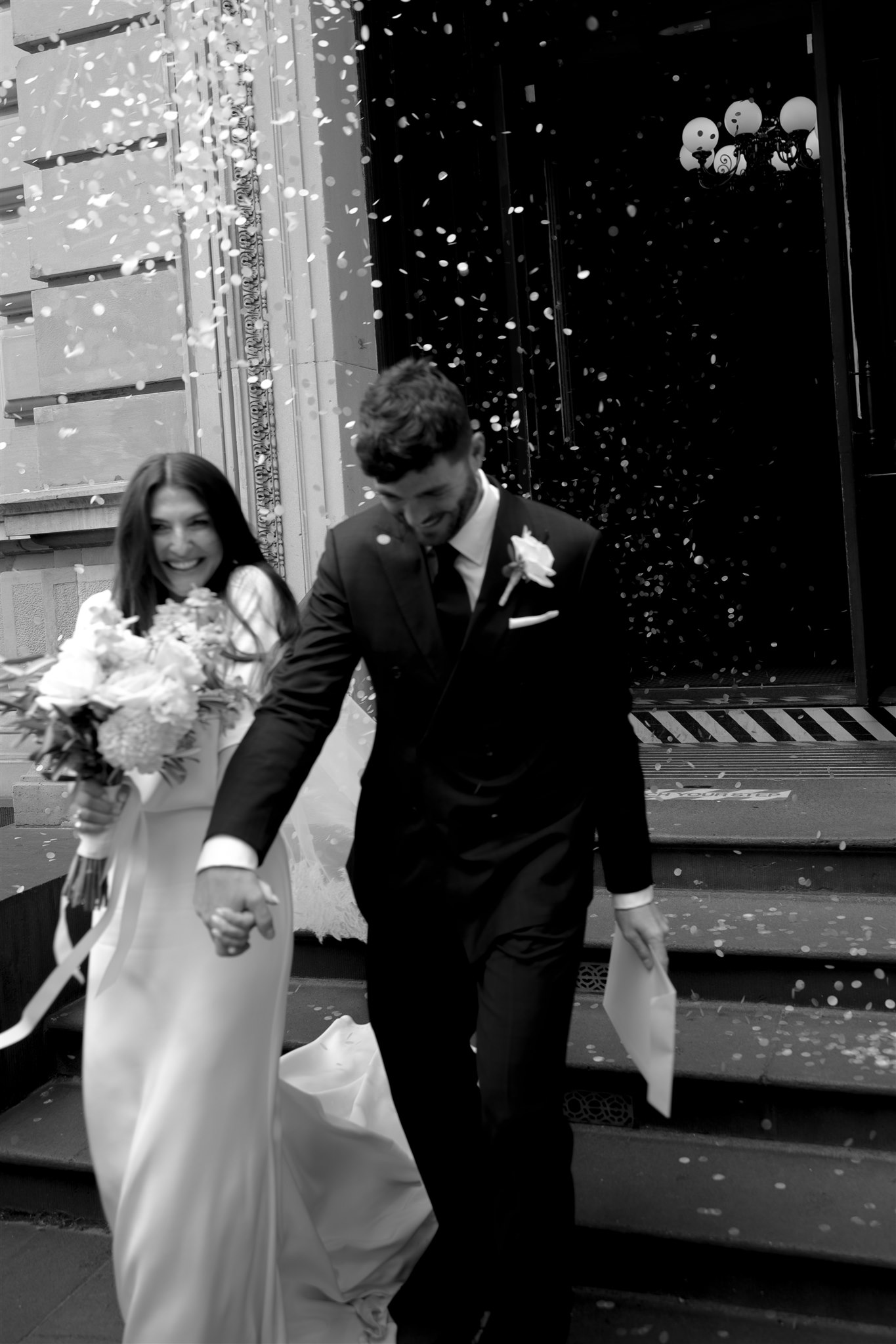 Stylish bride Lindsay in a Lola Varma dress and cowgirl boots, celebrating her Melbourne City elopement at the Melbourne Registry Office