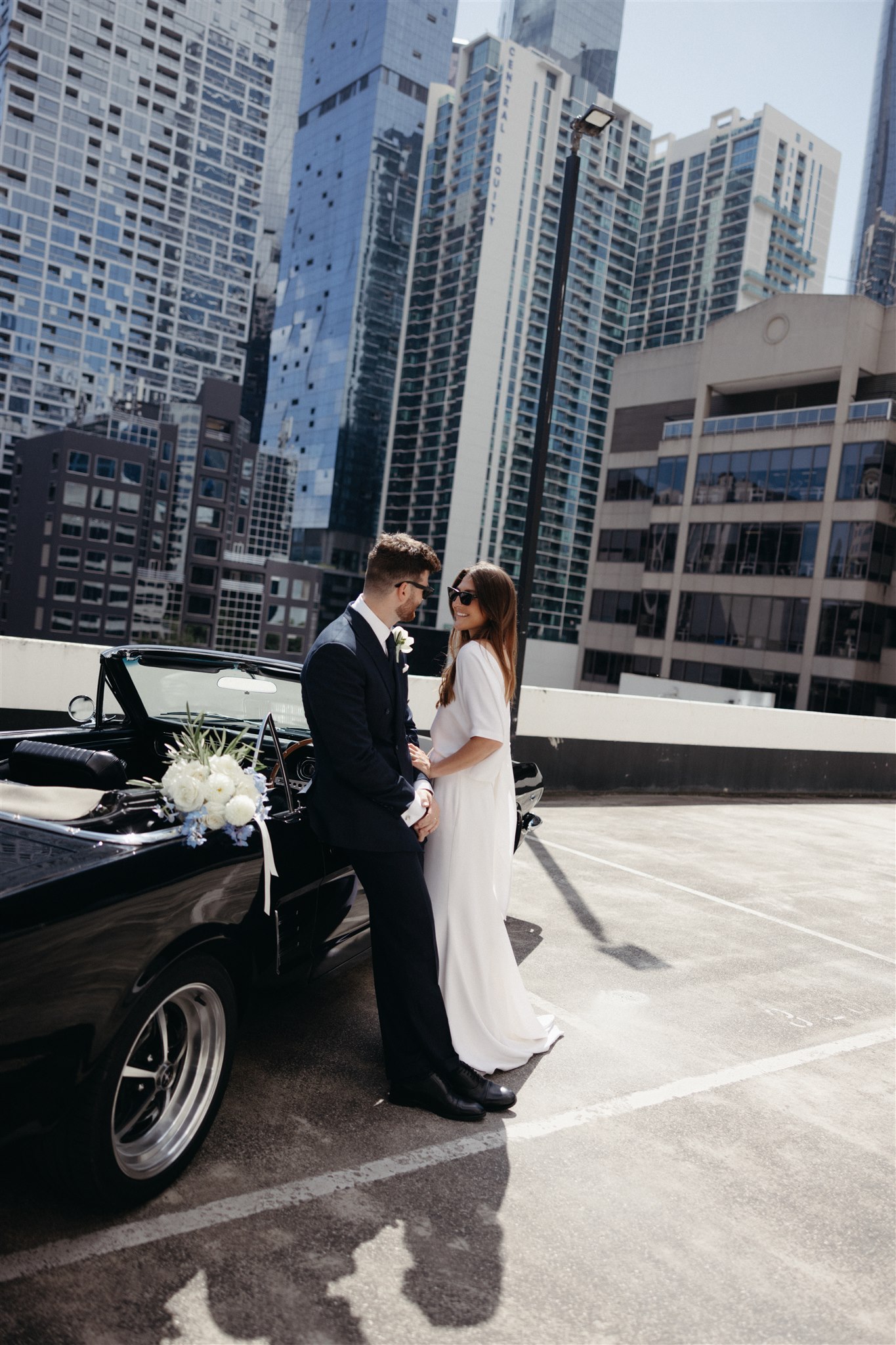 Stylish bride Lindsay in a Lola Varma dress and cowgirl boots, celebrating her Melbourne City elopement at the Melbourne Registry Office