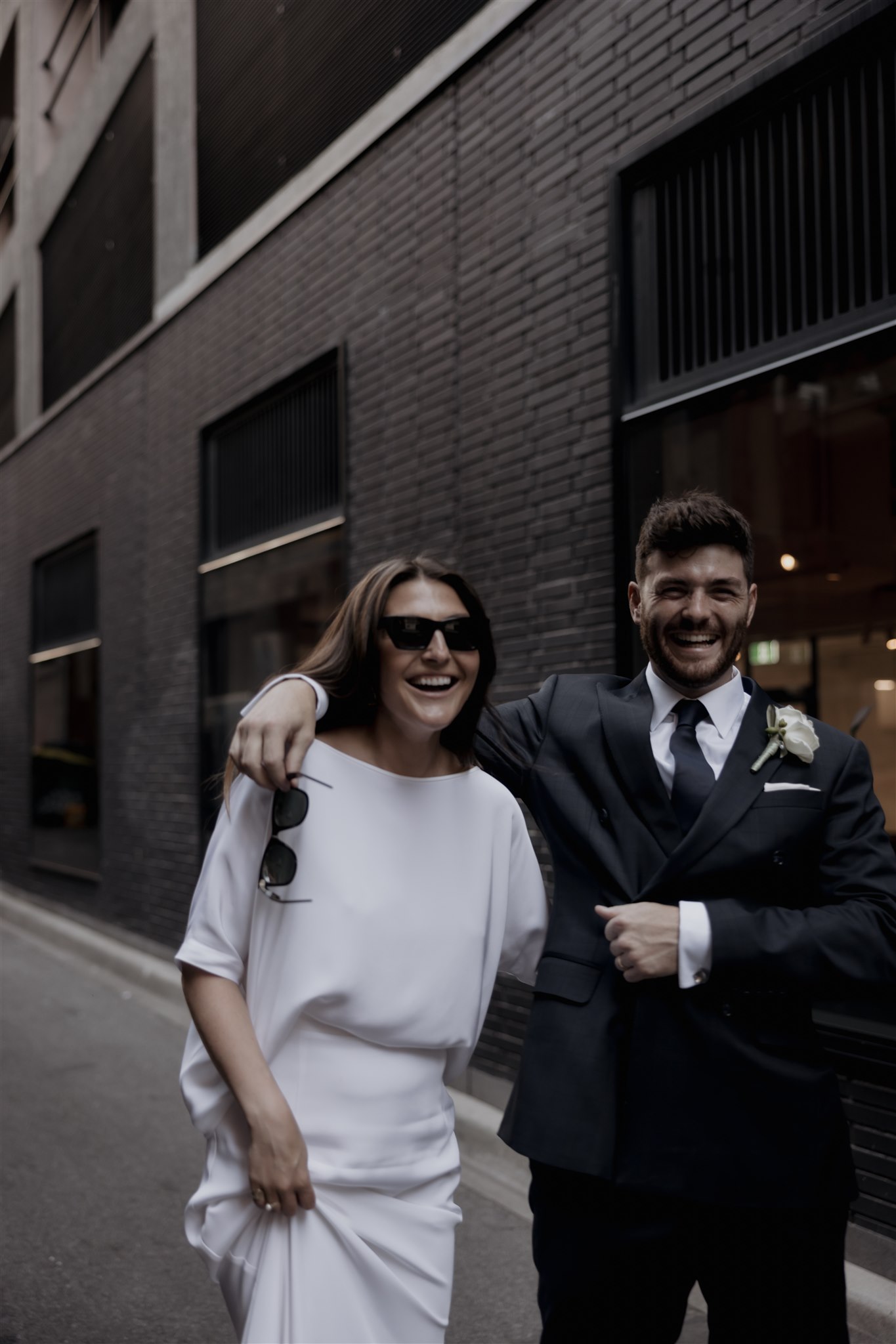 Stylish bride Lindsay in a Lola Varma dress and cowgirl boots, celebrating her Melbourne City elopement at the Melbourne Registry Office