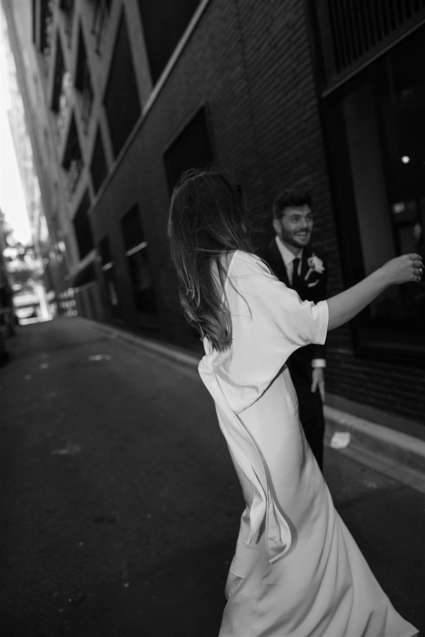 Stylish bride Lindsay in a Lola Varma dress and cowgirl boots, celebrating her Melbourne City elopement at the Melbourne Registry Office