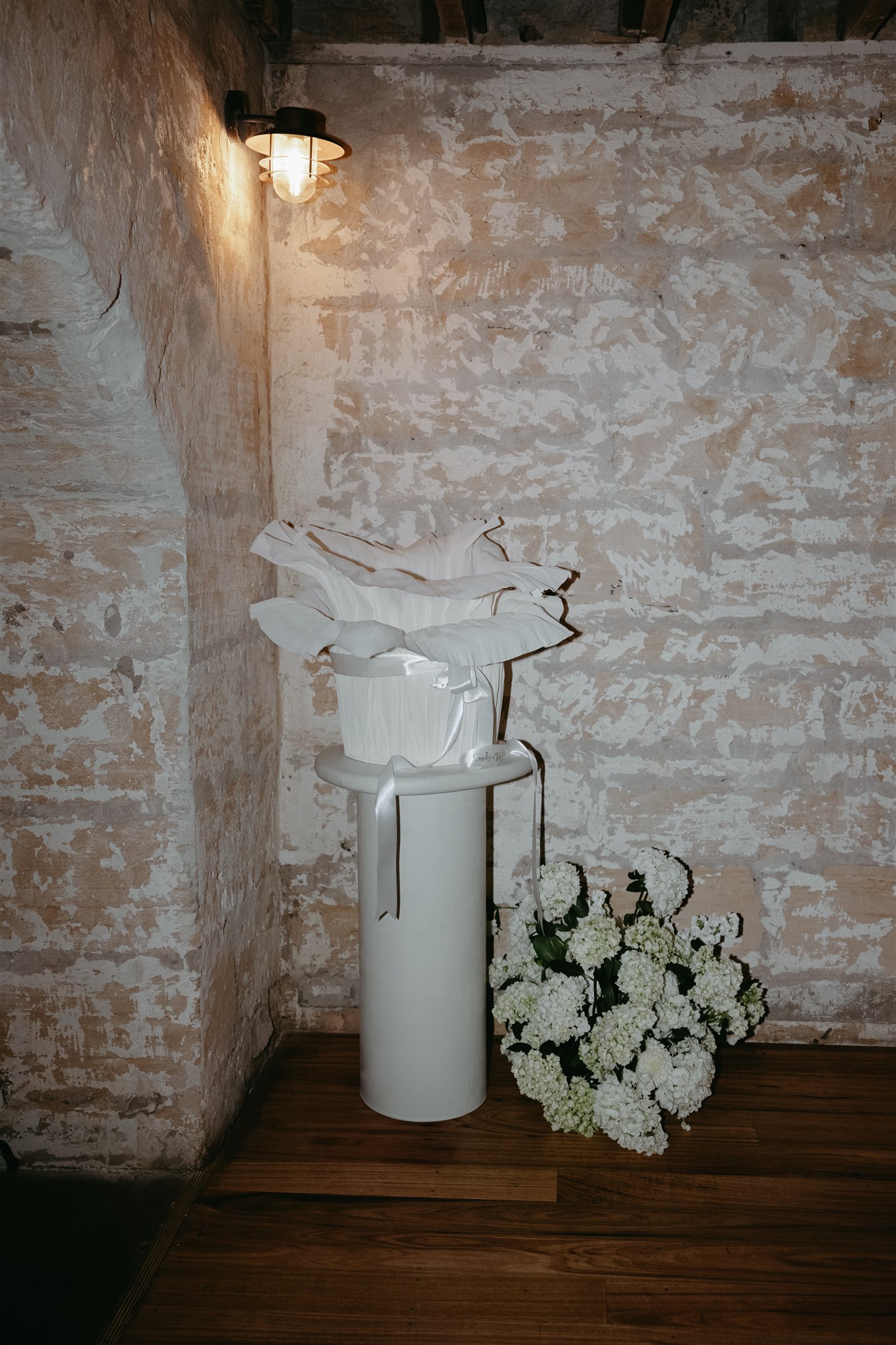 Unique wishing well. Elegant wedding styling with pearl-themed accents, premium linens, and vintage tableware at Lauren and Bernie’s romantic intimate wedding reception at Frolic Lane. Showcasing unique sandstone arches in the background. 35mm film wedding photography.