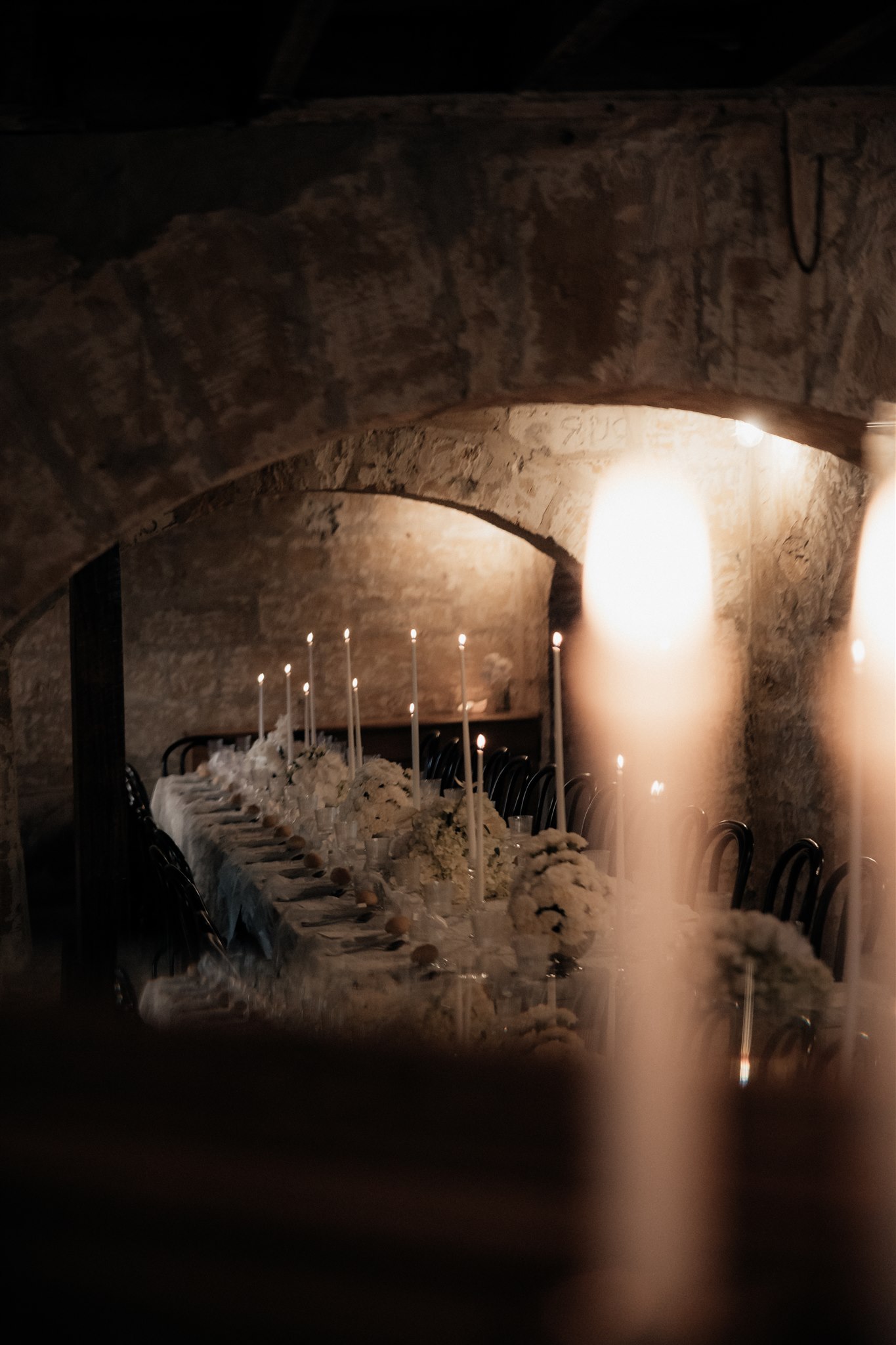 Elegant wedding styling with pearl-themed accents, premium linens, and vintage tableware at Lauren and Bernie’s romantic intimate wedding reception at Frolic Lane. Showcasing unique sandstone arches in the background. 35mm film wedding photography.