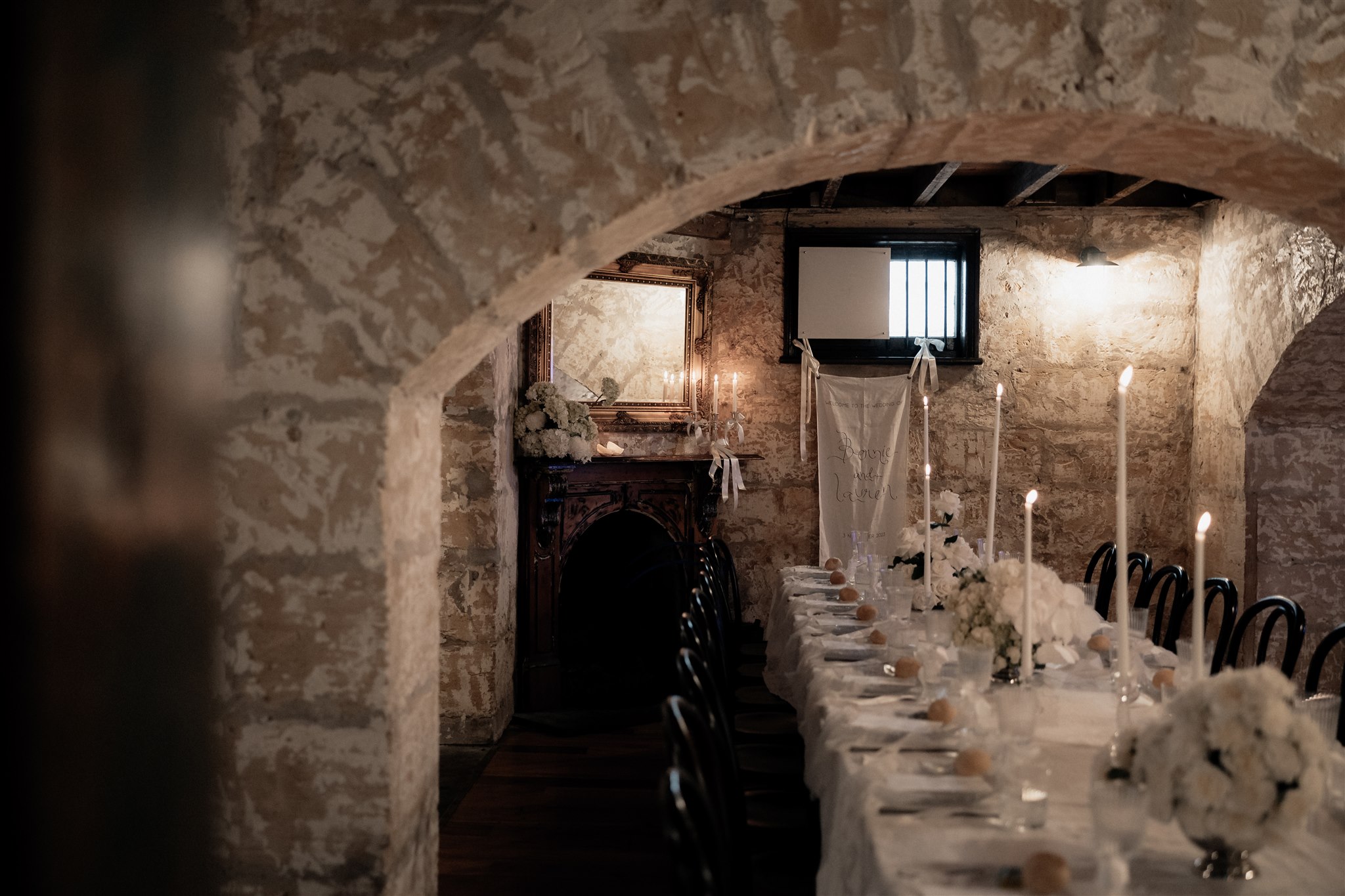 Elegant wedding styling with pearl-themed accents, premium linens, and vintage tableware at Lauren and Bernie’s romantic intimate wedding reception at Frolic Lane. Showcasing unique sandstone arches in the background. 35mm film wedding photography.