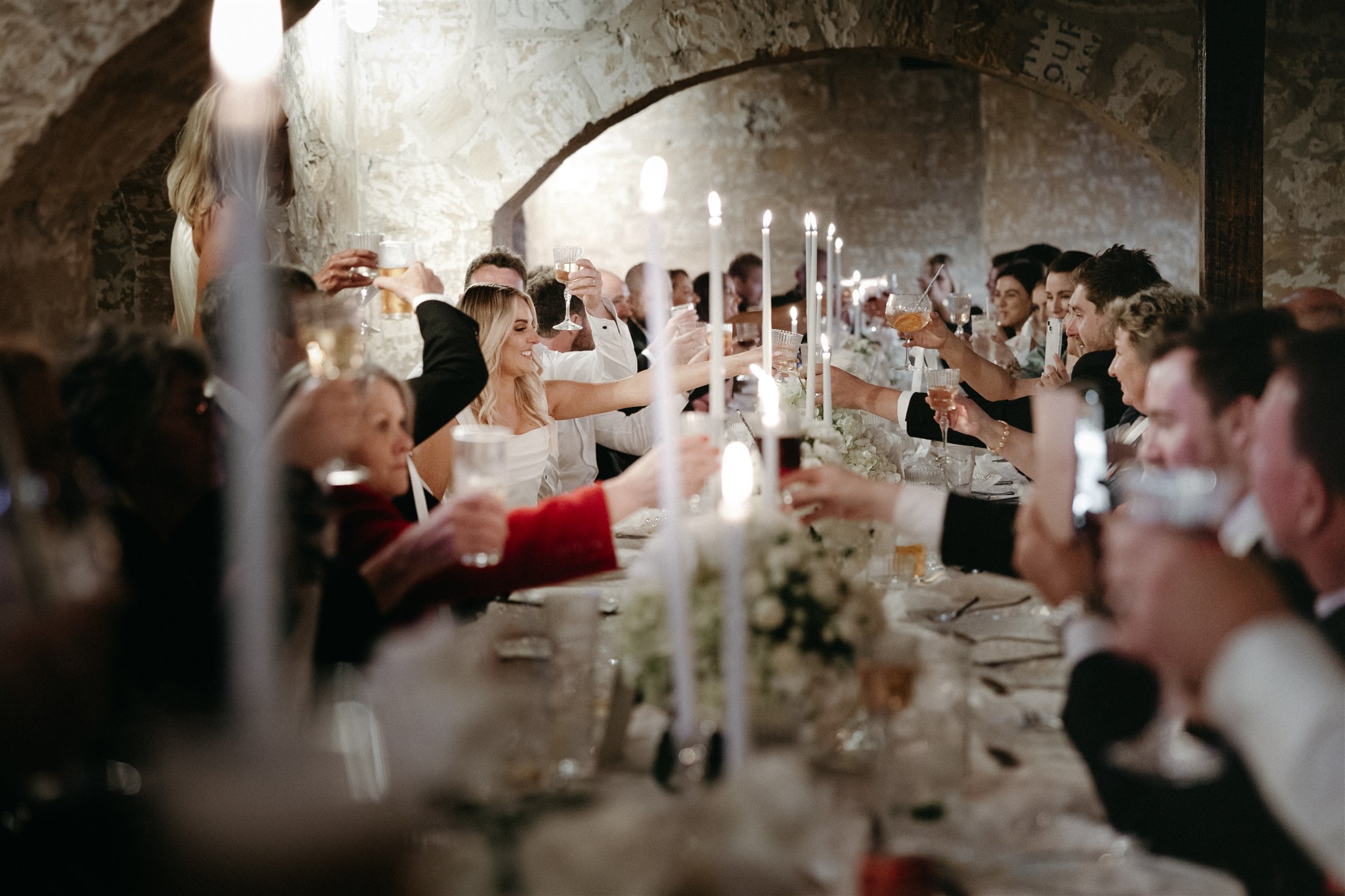 Elegant wedding styling with pearl-themed accents, premium linens, and vintage tableware at Lauren and Bernie’s romantic intimate wedding reception at Frolic Lane. Showcasing unique sandstone arches in the background. 35mm film wedding photography.