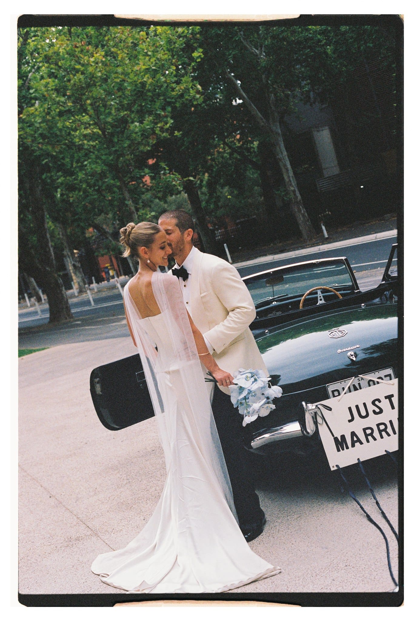 Georgina and Andrew Film photo of bride and groom and their wedding car in Adelaide